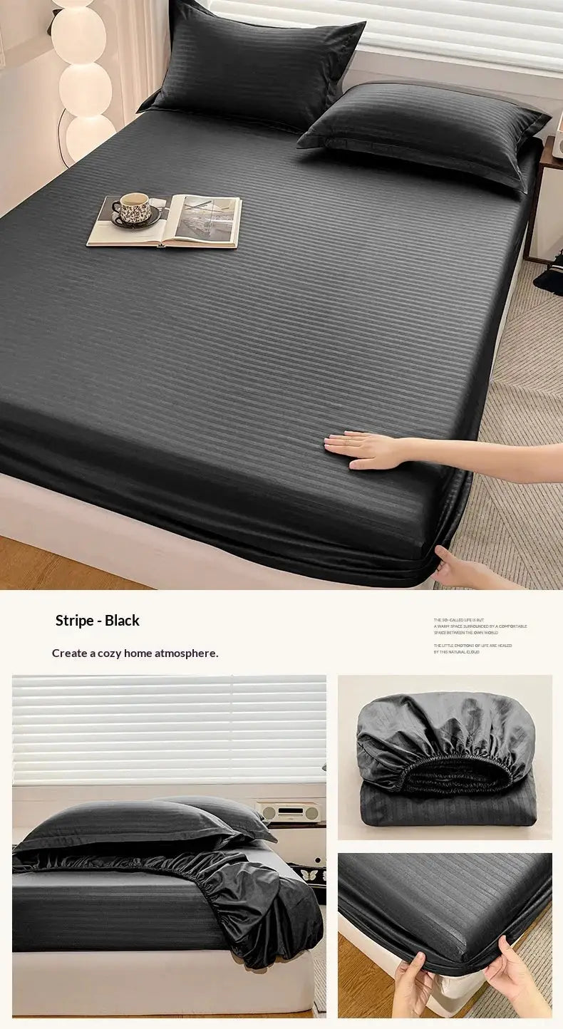 Fitted bed sheet with elastic edges in black striped fabric on a neatly made bed with pillows.