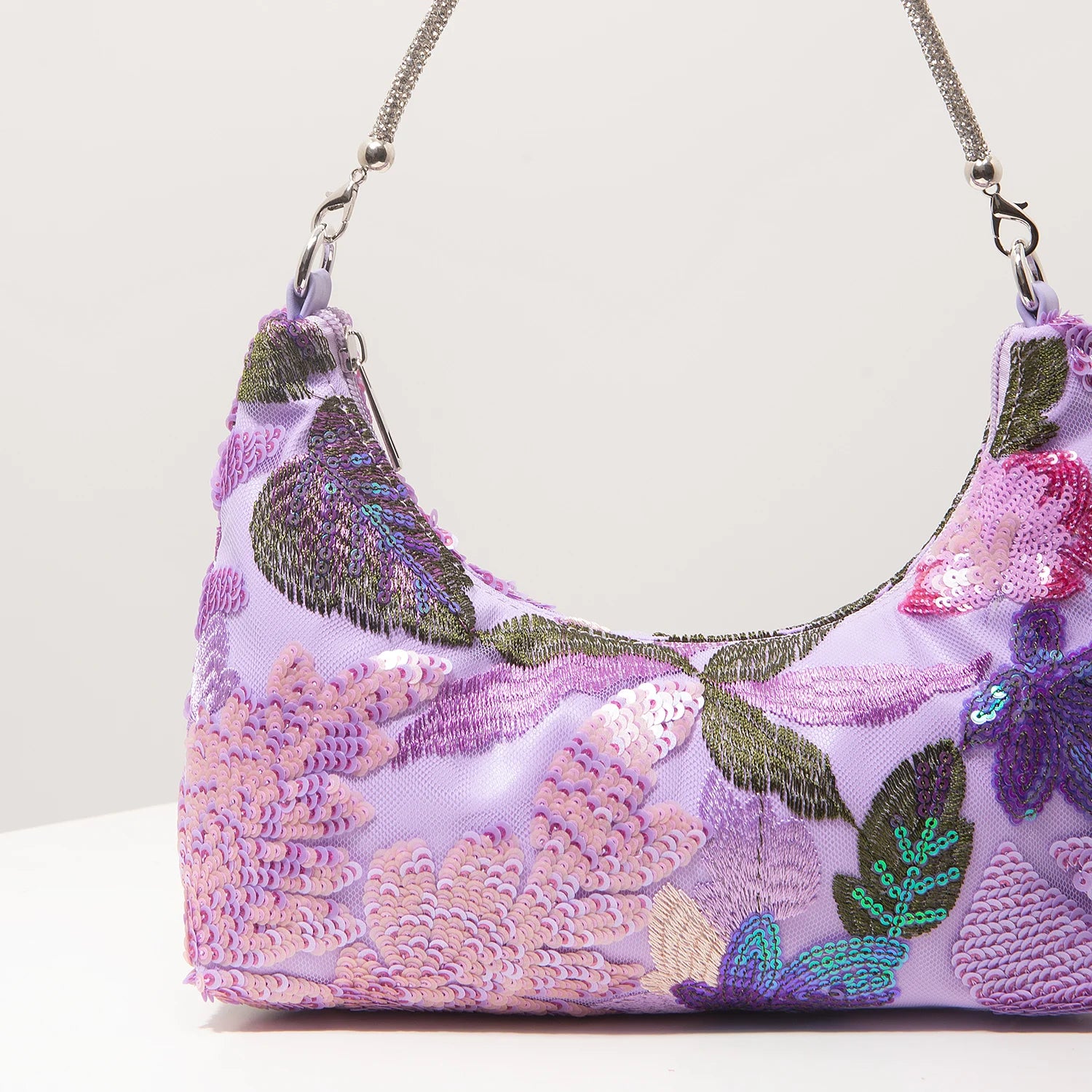 Shoulder bag with purple sequins and floral embroidery on lavender fabric, silver chain strap