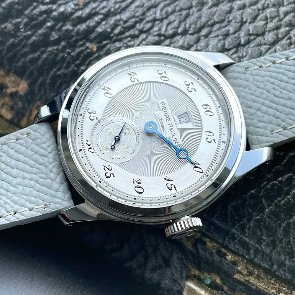 Pierre Paulin Jumping Hour men's watch with salmon dial, blue hands, date window, stainless steel case, leather strap.