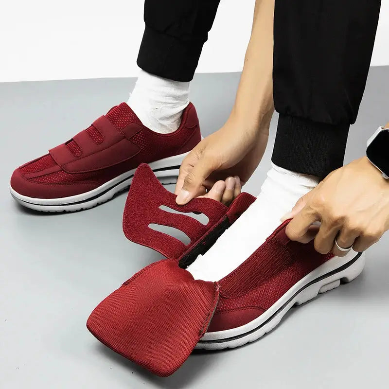 Pair of red wide-toe orthopedic sneakers for swollen feet with white soles