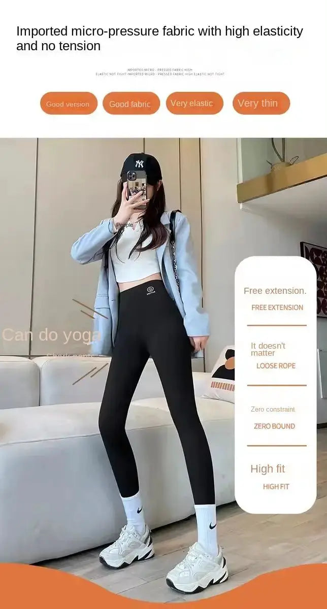 Black high-waisted yoga leggings by Simples Market on a model in a light blue hoodie with white sneakers for an athleisure look.