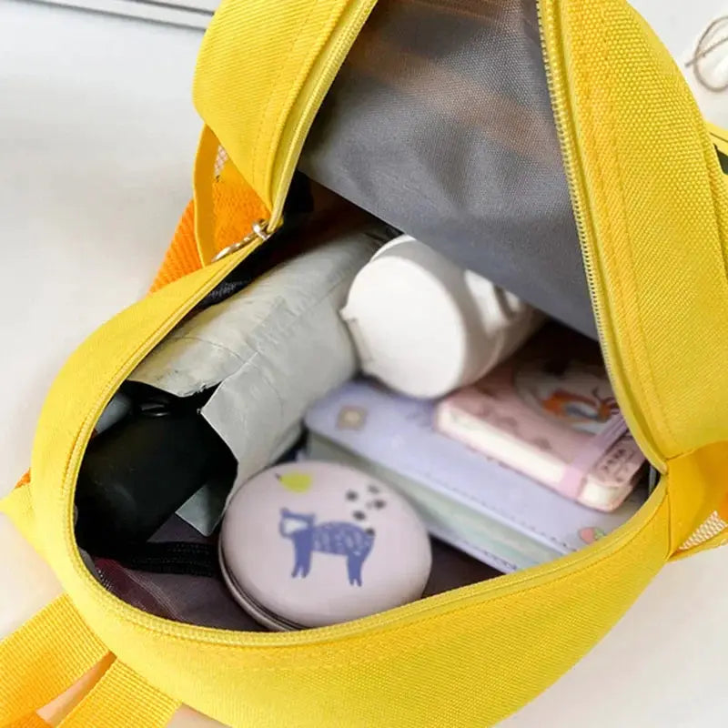 Police-car kids backpack by Simples Market, bright yellow, open to reveal books and small accessories
