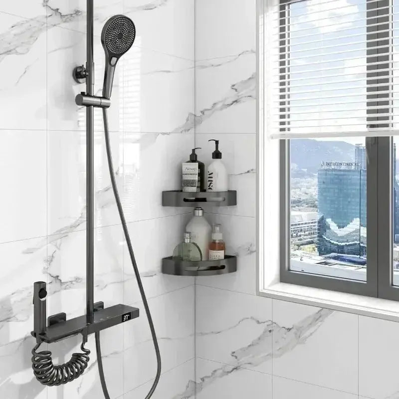 Shower system in black, wall-mounted with handheld head and coiled hose in marble-tile bathroom.