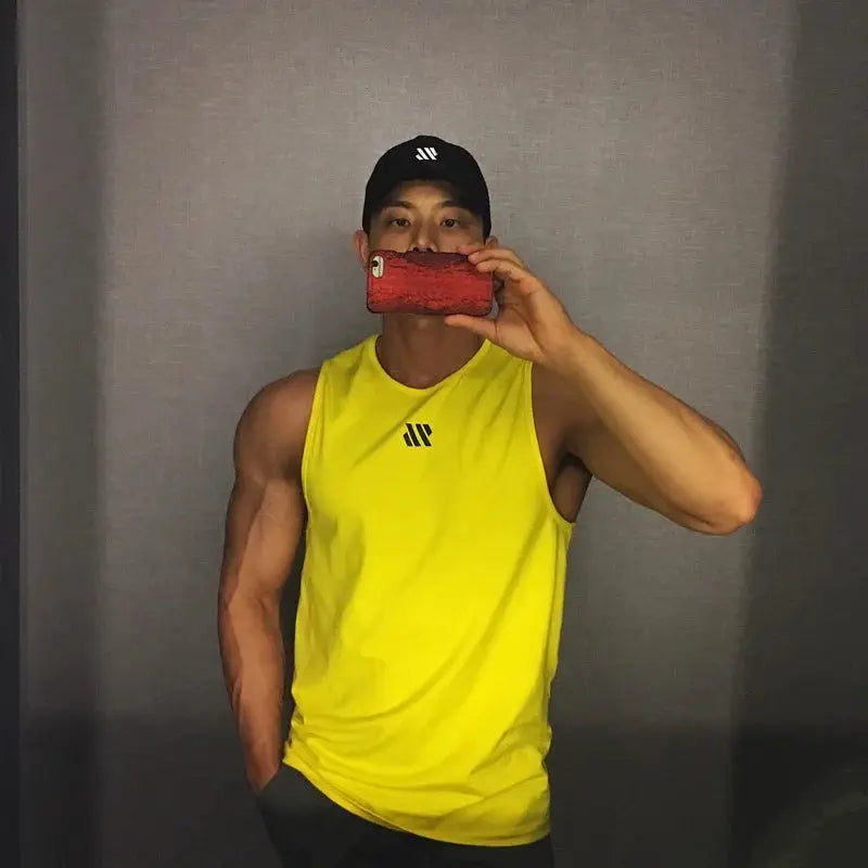 Tank top by Simples Market; neon yellow men's sleeveless gym tank with chest logo