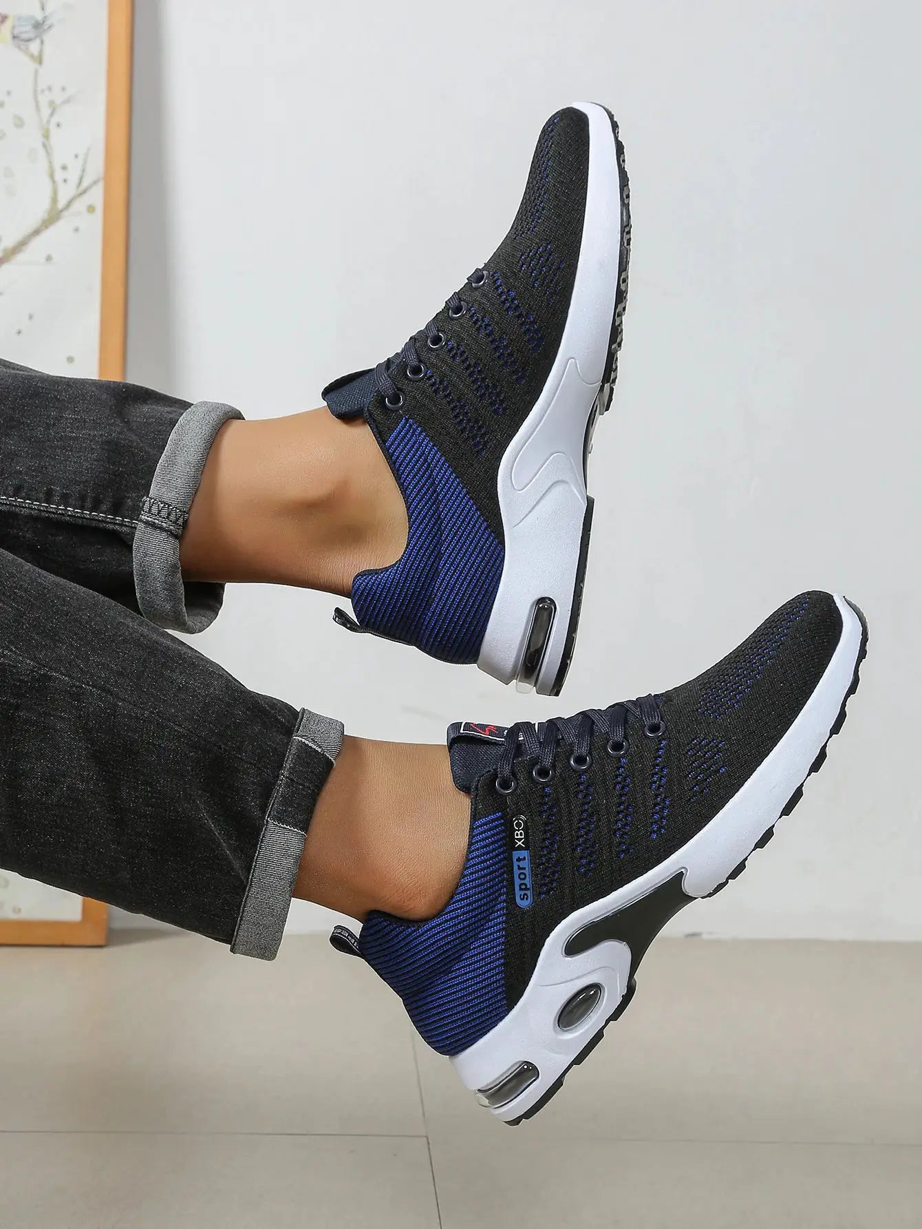 Men's breathable lace-up running shoes, black knit with blue accents and white sole, pair.