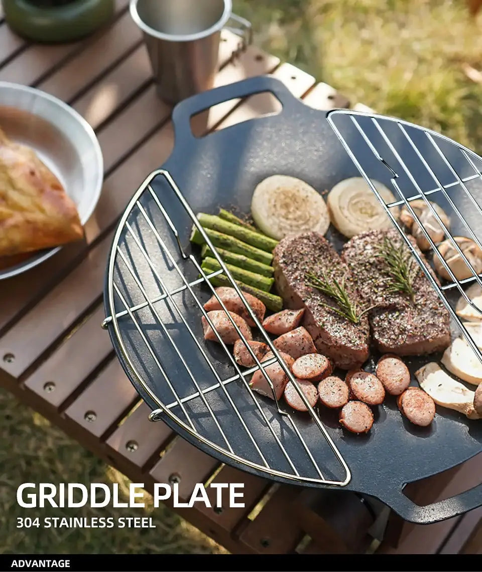 Barbecue net steam rack in stainless steel on a frying pan with meat, onions and asparagus outdoors grill