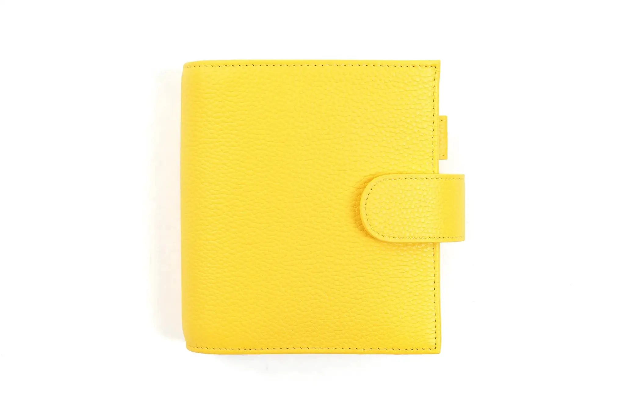 Pocket-size planner in yellow pebbled leather with strap closure.