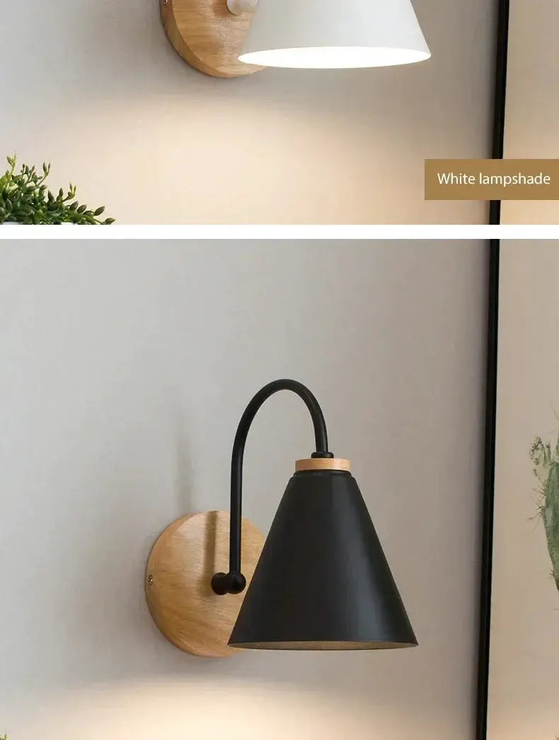 Two Nordic wall sconces with wooden backplates, one white lampshade and one black metal cone shade.
