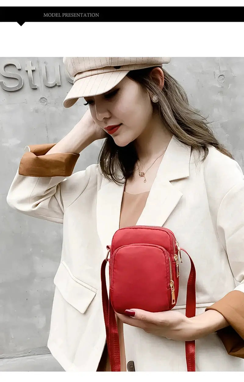 Women's red waterproof crossbody bag with zipper pockets and long strap
