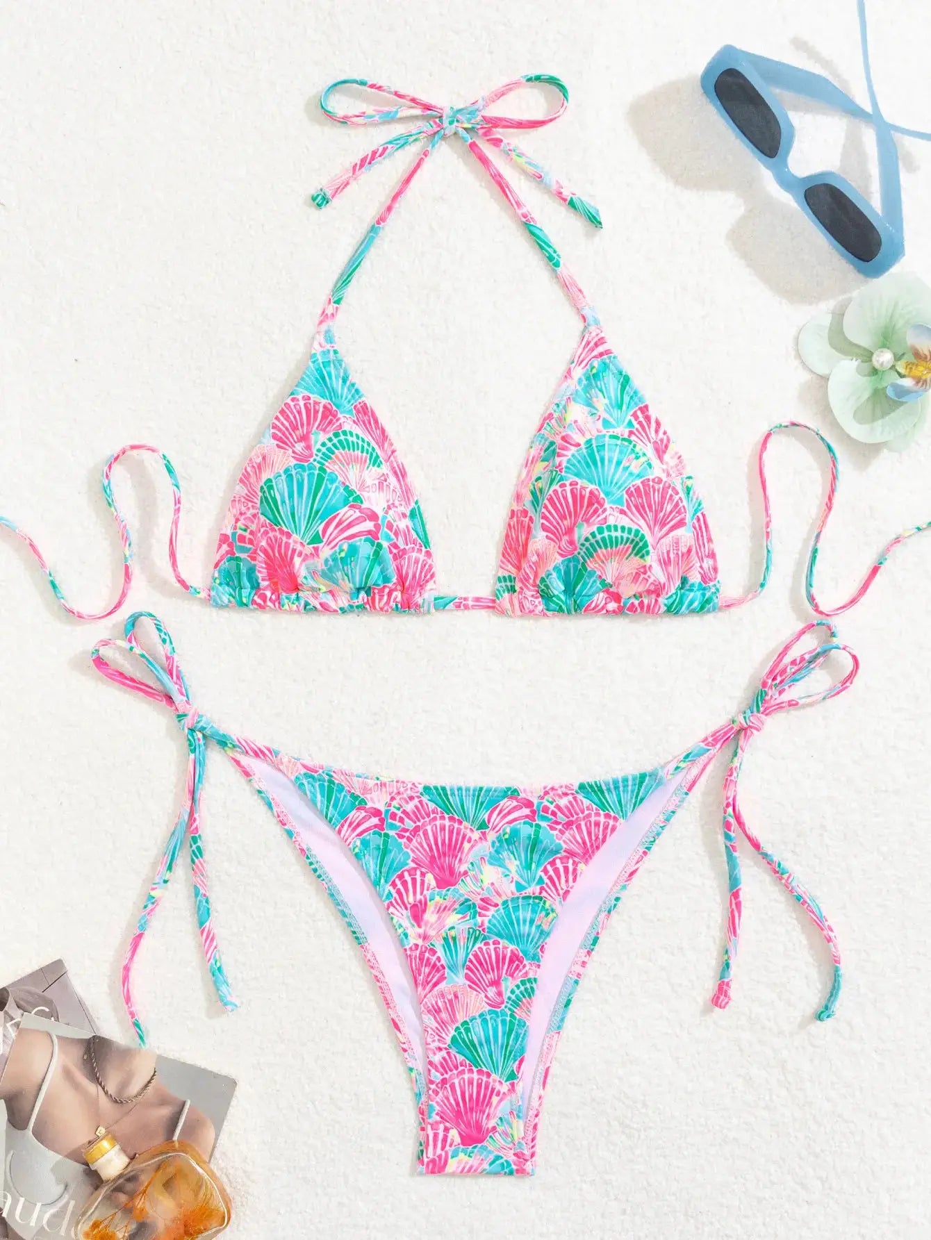 Two-piece bikini set with pink and turquoise seashell pattern; triangle top with adjustable ties and string bottoms.