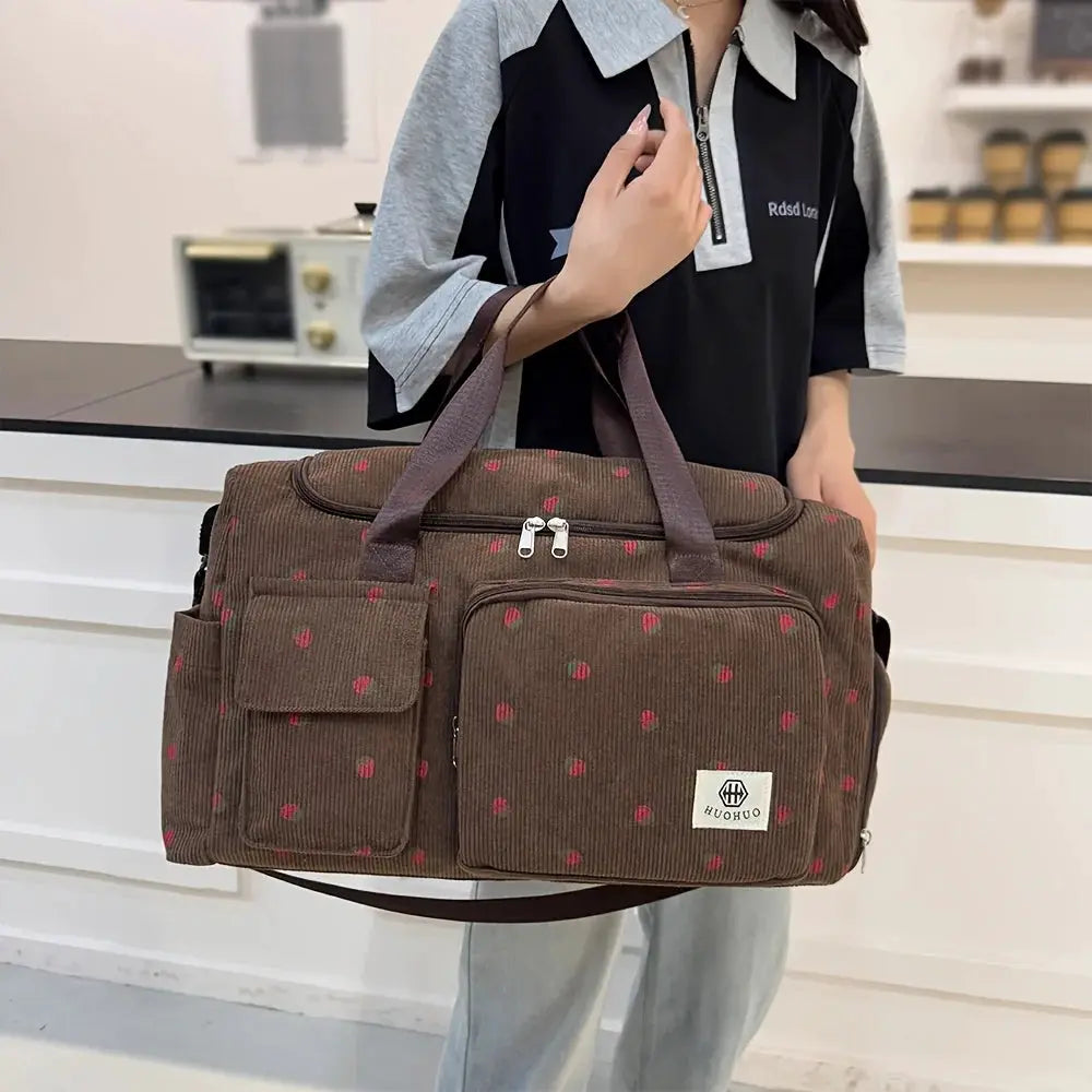 Strawberry travel bag in brown corduroy with large capacity, front pockets, crossbody strap, HUOHUO logo.