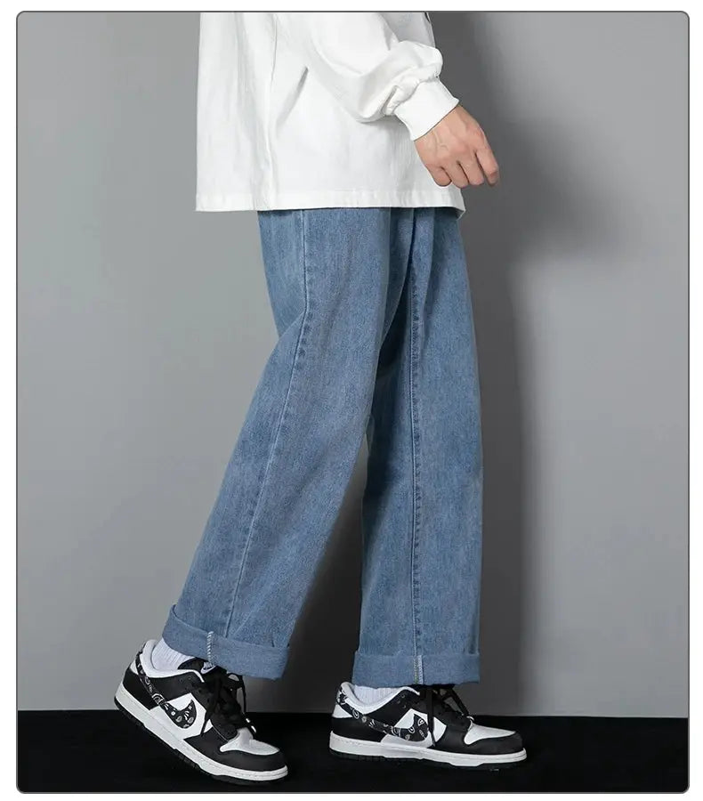 Men's light blue denim wide-leg straight jeans with cuffed hems, casual style.