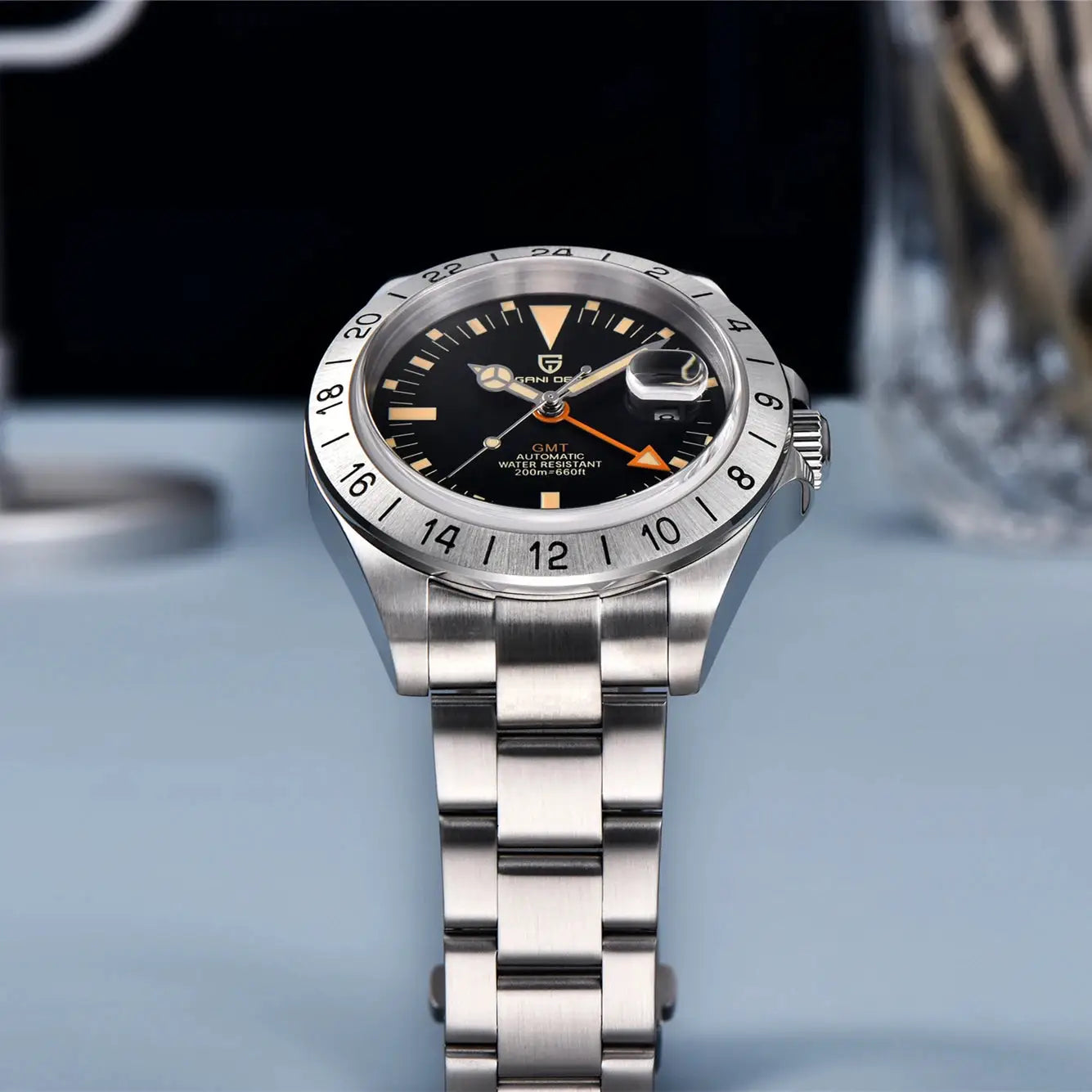 Pagani Design GMT men's stainless steel watch with black dial, 24-hour bezel, orange GMT hand, and date magnifier.