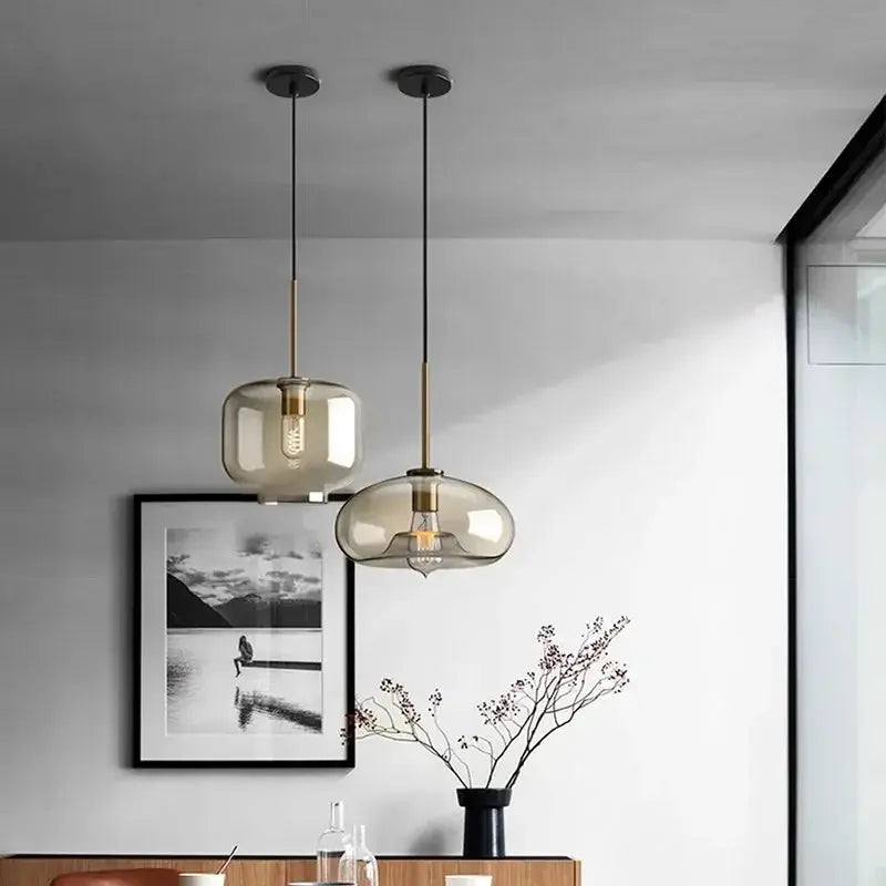 Nordic LED glass pendant lights, two amber-tinted shades with gold-tone fittings on black cords