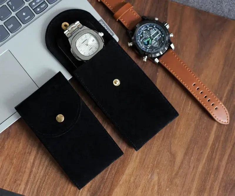 2 black flannelette watch storage pouches with gold snaps, shown with a brown leather strap watch
