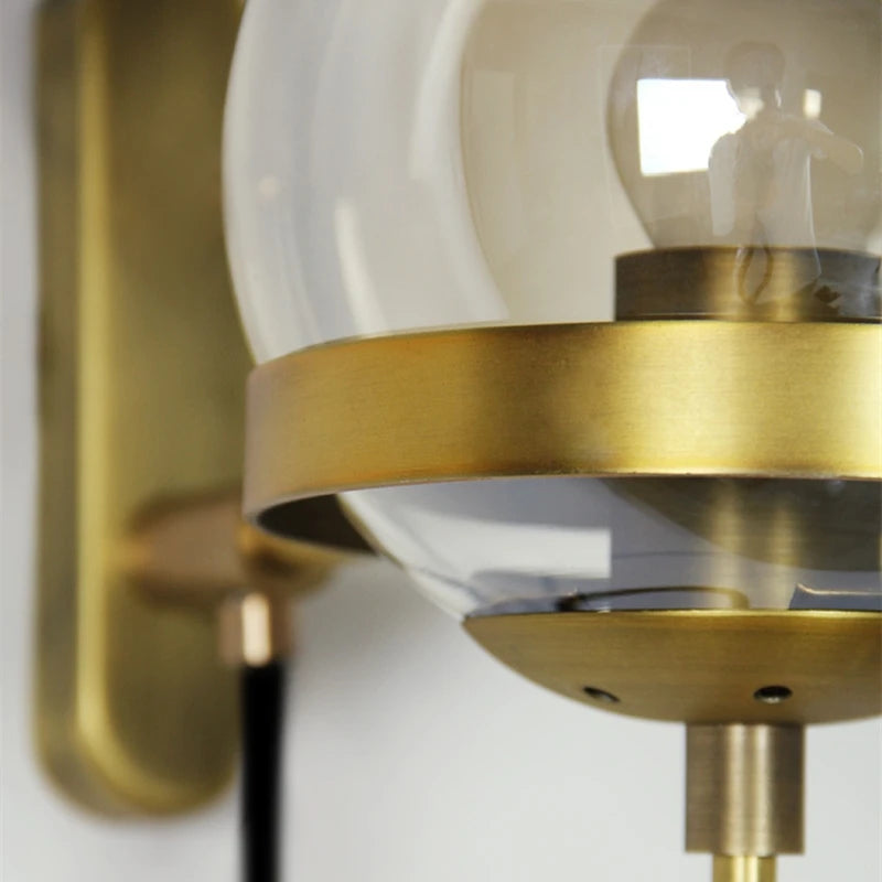 Modern glass ball wall lamp with brass ring and clear globe, wall-mounted fixture