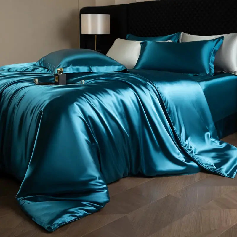 Silk bed sheet set in teal satin with duvet cover, fitted and flat sheets, and pillowcases