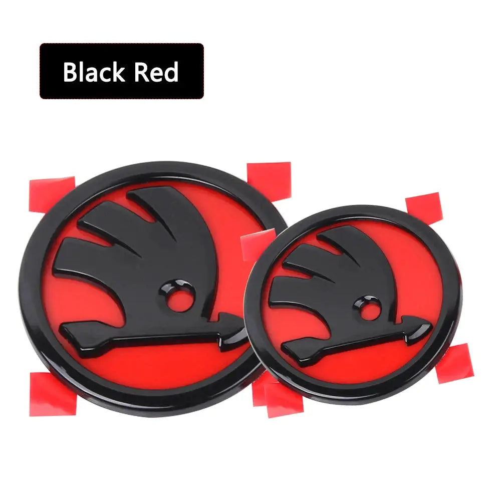 Two black circular Skoda badge emblems on red background for front and rear