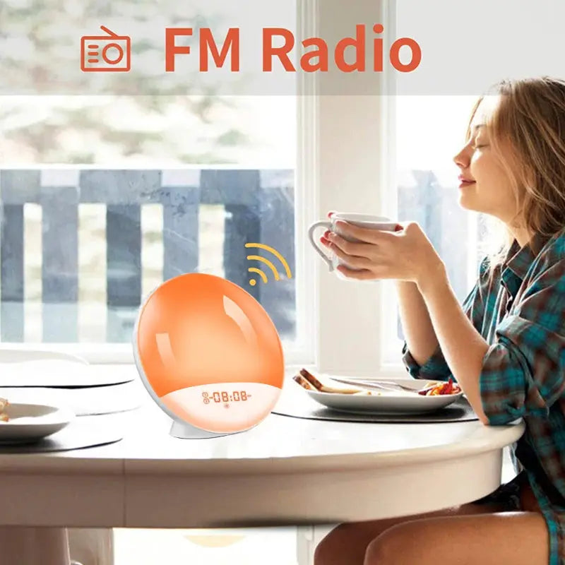 Sunrise alarm clock with orange glow and digital display on a round white table beside a coffee cup