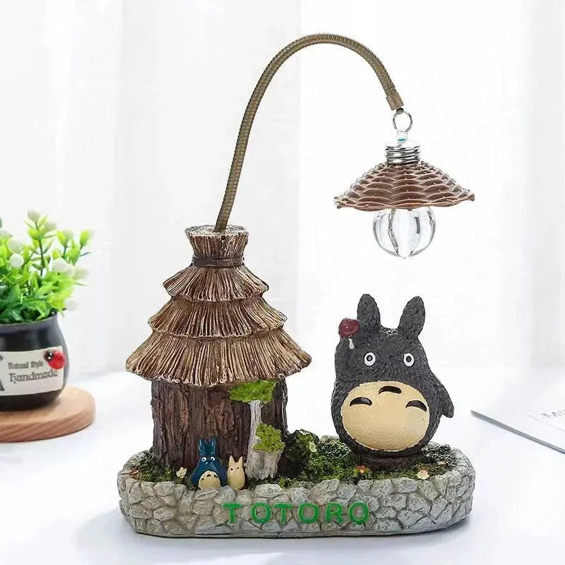Totoro-themed LED desk lamp with thatched-roof hut base, flexible gooseneck and hanging bulb, decorative ornament.