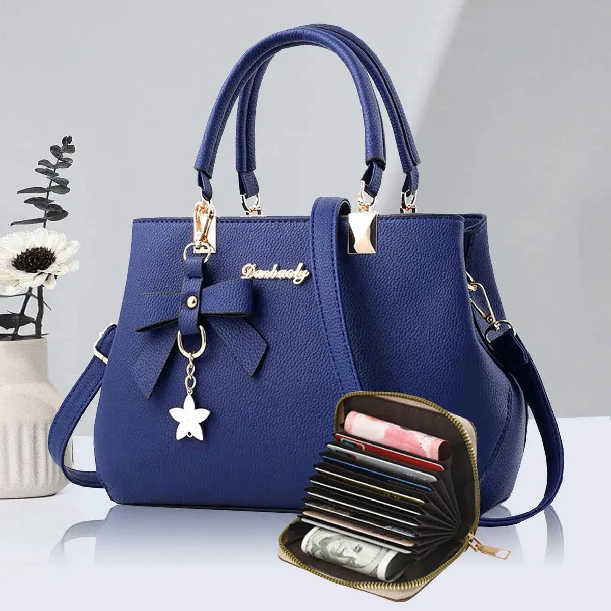 Blue faux leather handbag with double handles, gold hardware, bow charm; includes matching wallet with card slots.