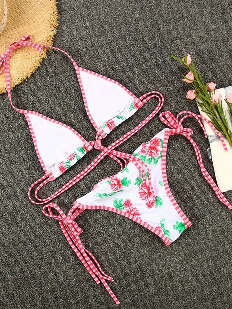Two-piece bikini set with white fabric, pink floral print, and pink gingham trim; triangle top and tie-side bottoms