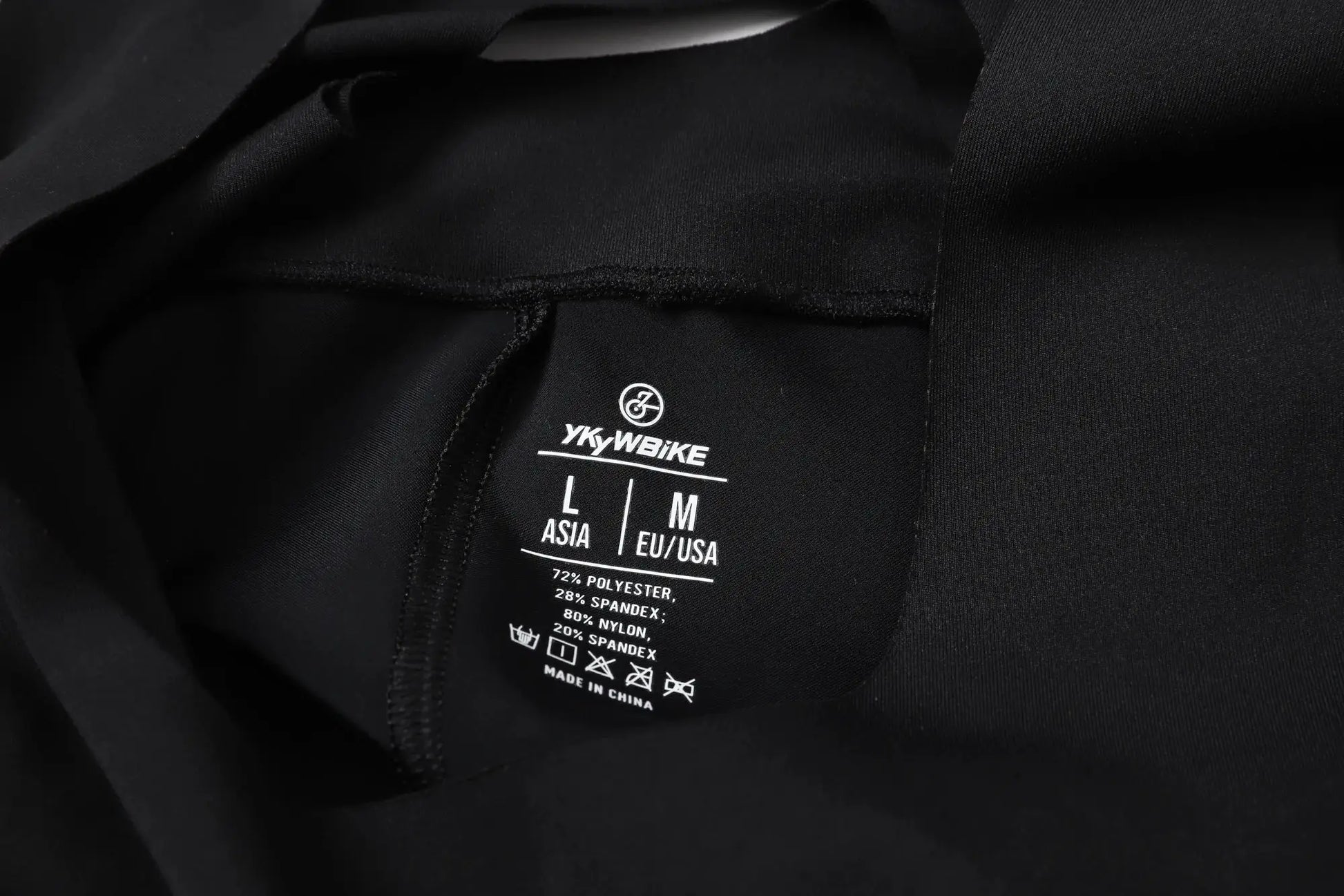 YKYWBIKE black cycling bib shorts tag on dark fabric showing sizes L and M.