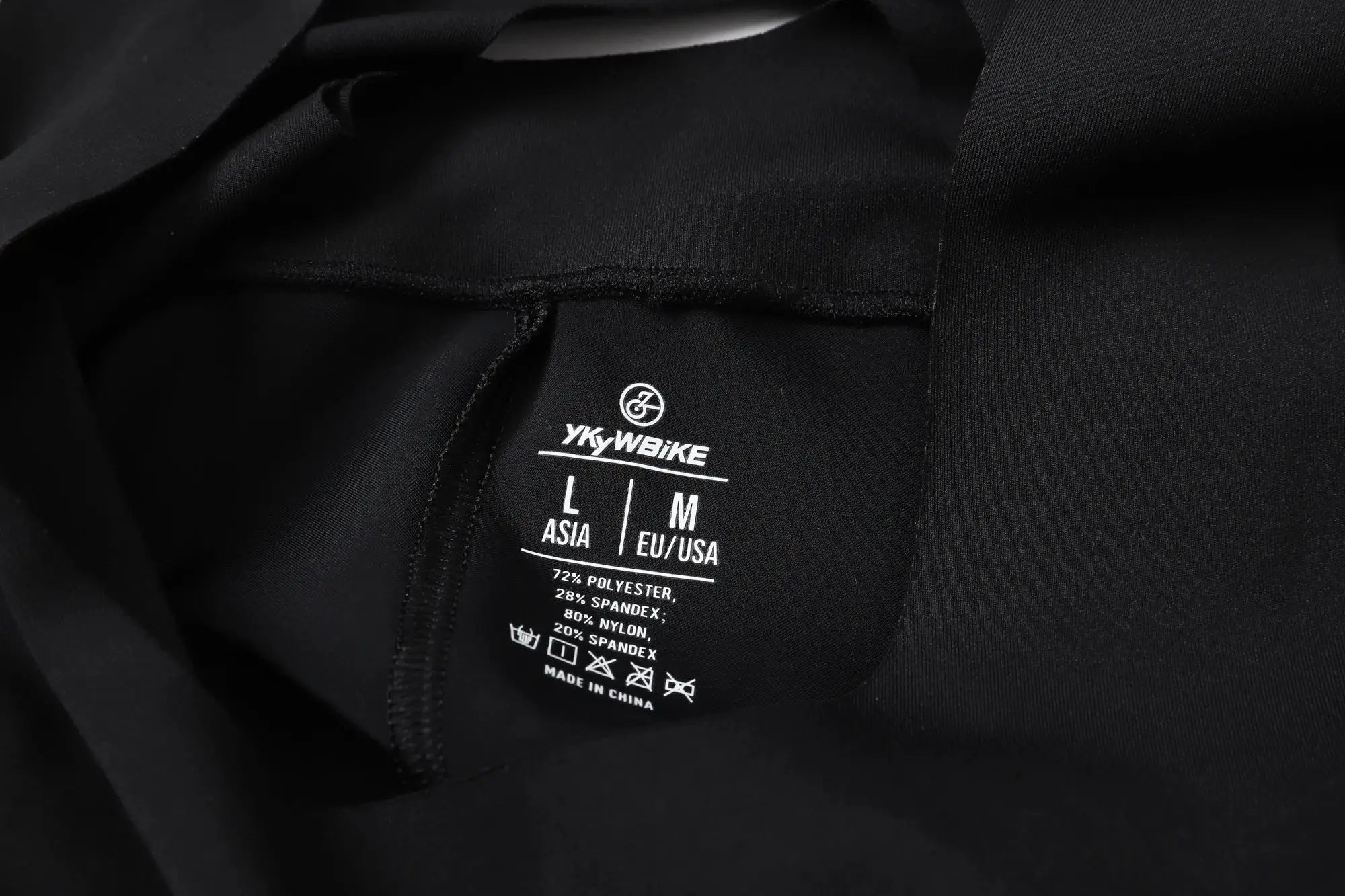 YKYWBIKE black cycling bib shorts tag on dark fabric showing sizes L and M.