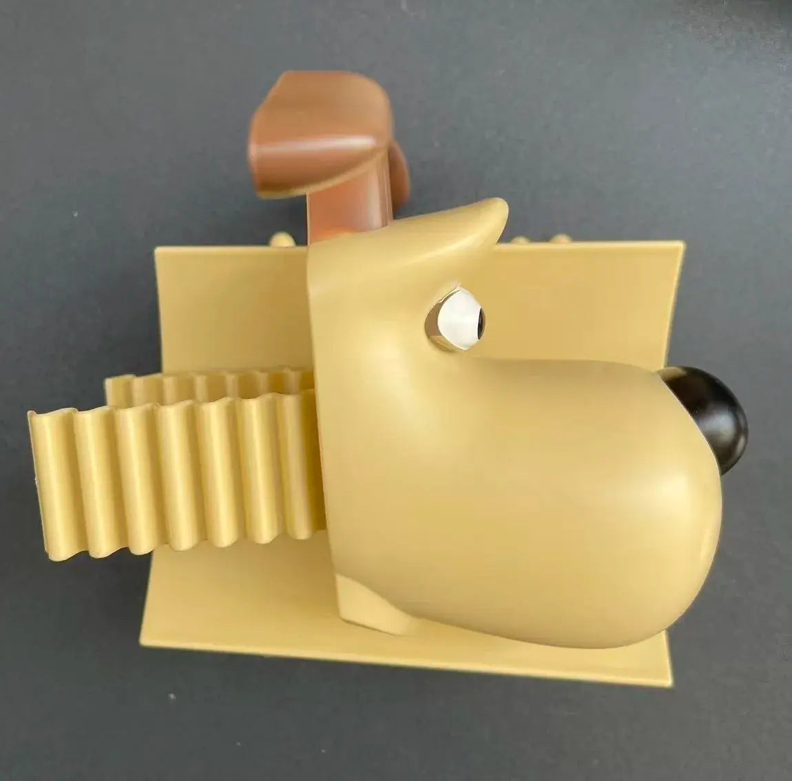 Fun dog raccoon sheep toilet paper holder in yellow-gold finish; wall-mounted base.