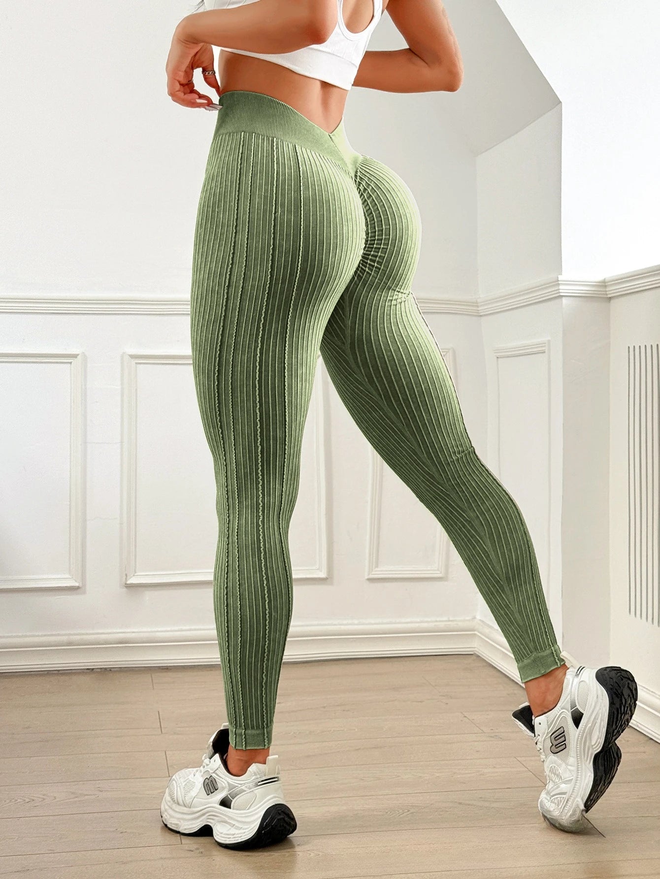Women's ribbed high-waisted green yoga leggings with V-shaped waistband for workouts