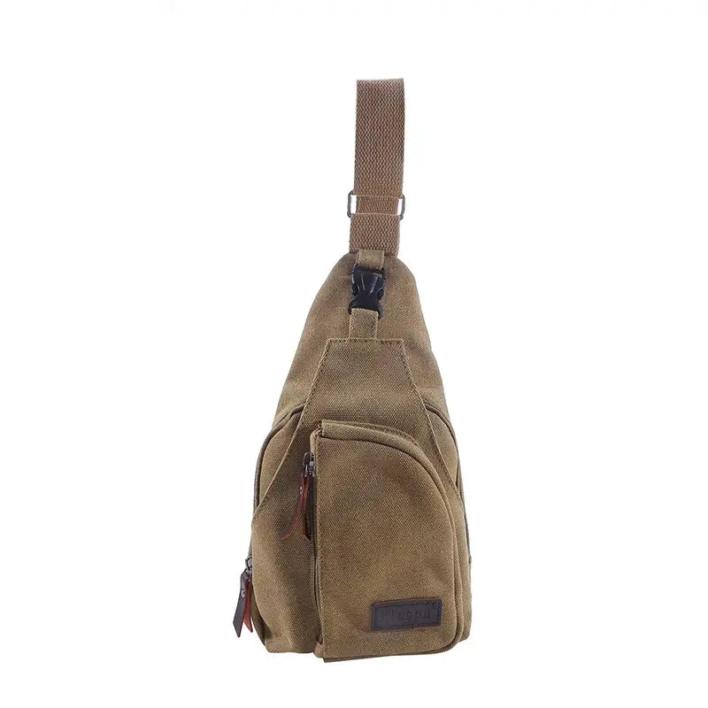 Canvas sling bag by Simples Market in brown canvas with front zip pockets and adjustable strap.