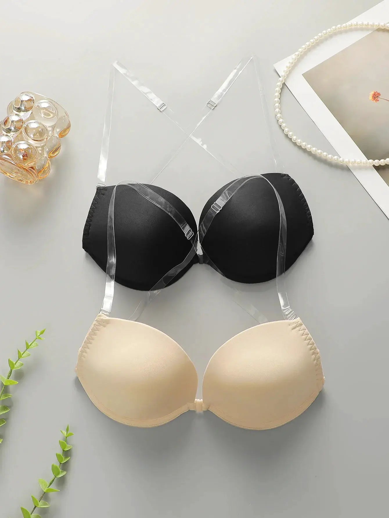 Simples Market backless front-closure push-up bra with transparent straps; two bras in black and nude.