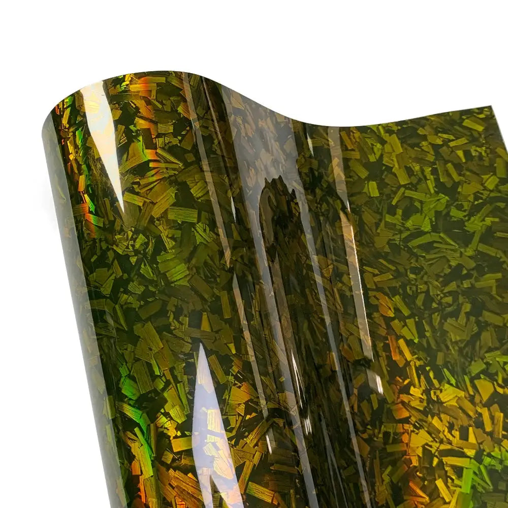 Car body wrap film, glossy forged carbon fiber, self-adhesive with iridescent green-gold flakes.