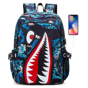 Shark-print kids backpack by Simples Market with blue/black geometric pattern and large shark mouth graphic