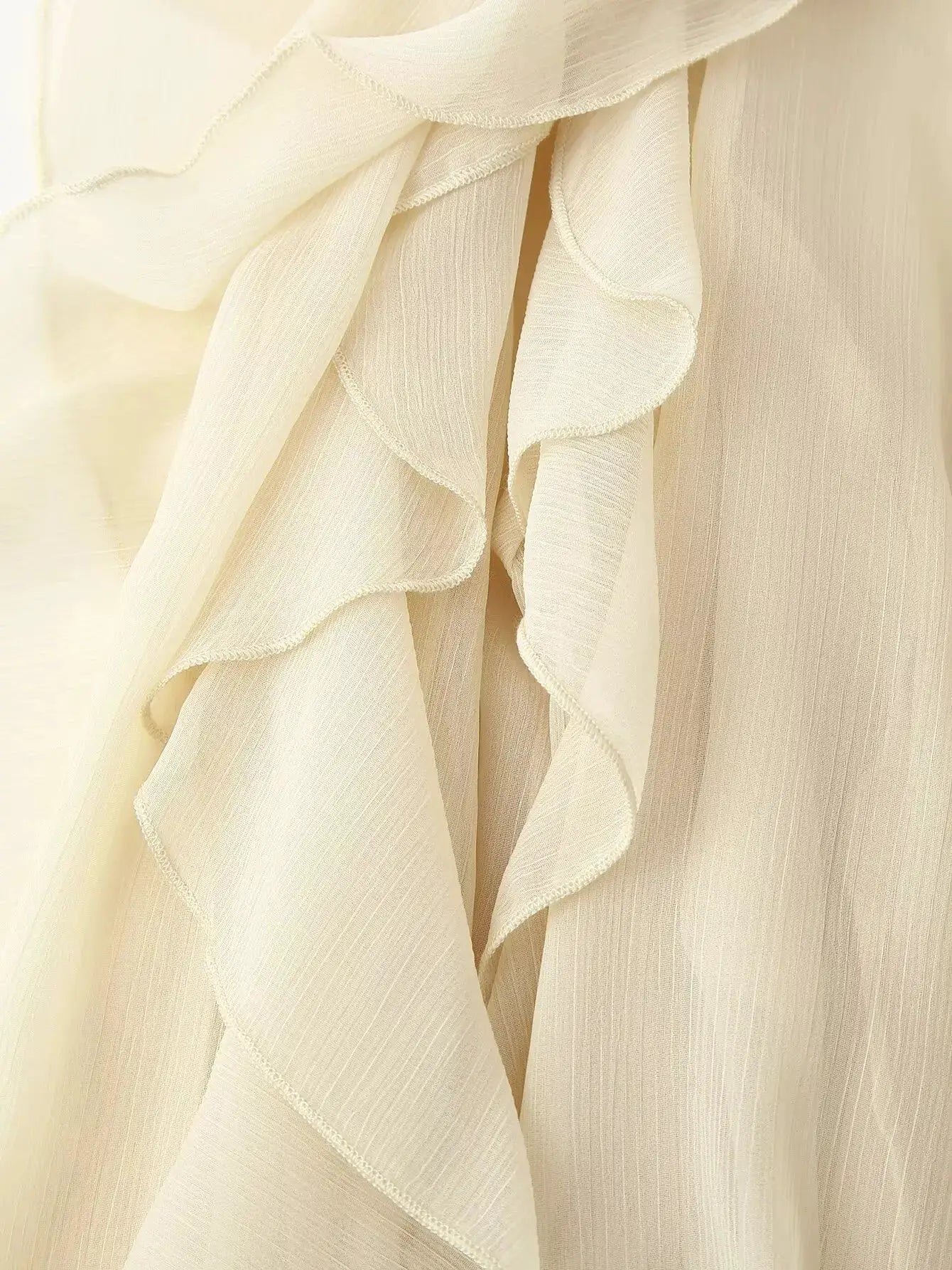 Cream ruffle blouse with layered front, long sleeves and V-neck, semi-sheer textured fabric
