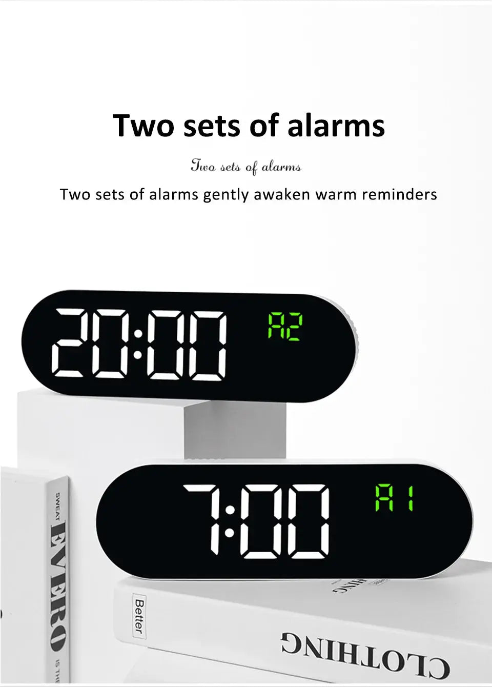 Digital LED wall clock with two alarm sets; black oval clocks with large white digits and green indicators, placed on white books