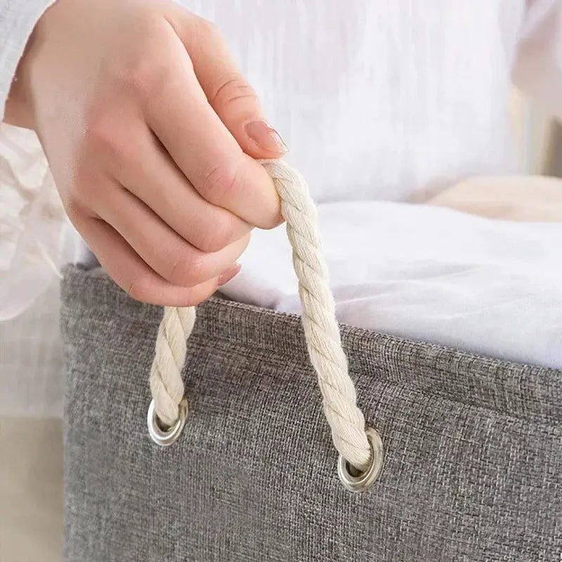 Gray linen storage basket with cream rope handles and metal eyelets