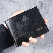 Black leather slim men's wallet with embossed eagle pattern, held in hand.
