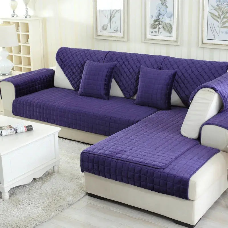 Plush plaid quilted sofa cover set in purple velvet with matching cushions on beige sectional