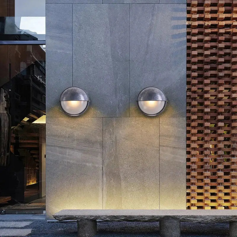 Outdoor retro LED wall lamps (2) with glass shades and metal gray finish, warm glow on a gray wall.