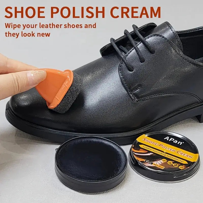 Faux leather shoe polishing kit with orange applicator and colorless wax, APAN tin beside a black dress shoe