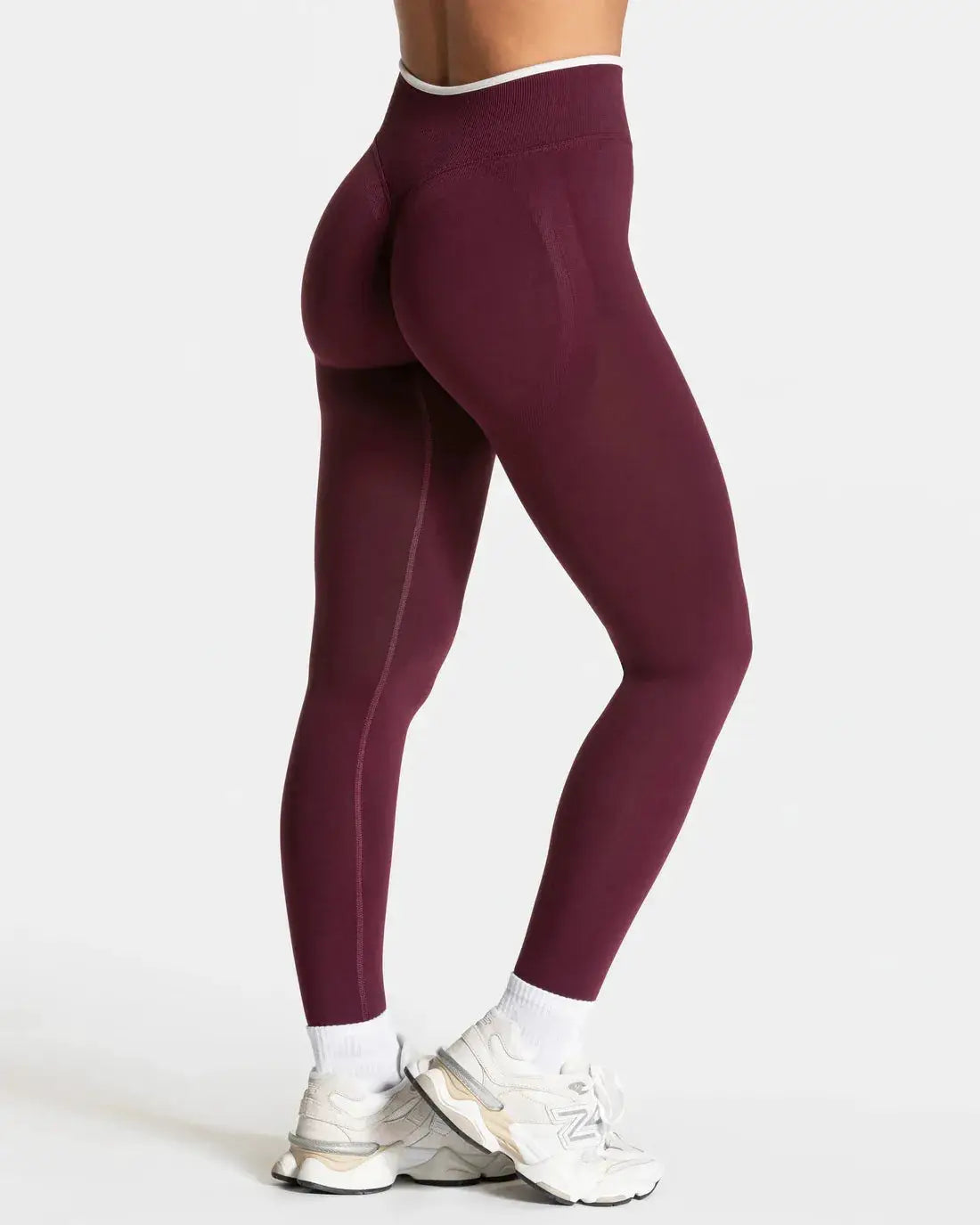Women's seamless knit yoga leggings, high-waist maroon with white-edge waistband for workouts.