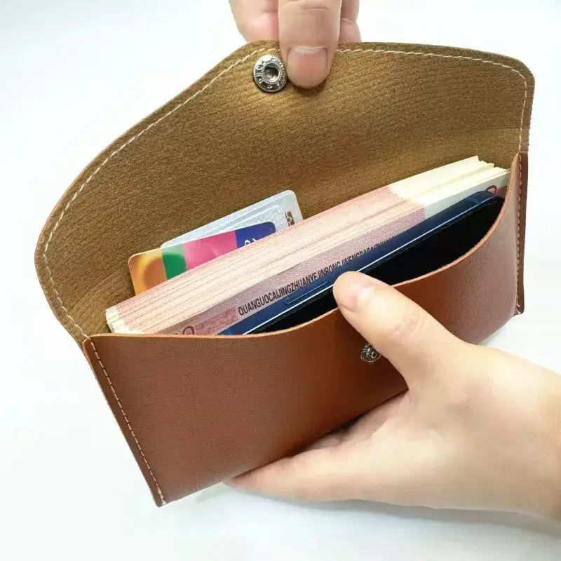 Unisex brown leather long wallet opened to reveal cash and cards.