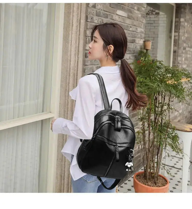 Bear backpack for women, black faux-leather with front zip pockets and bear charm