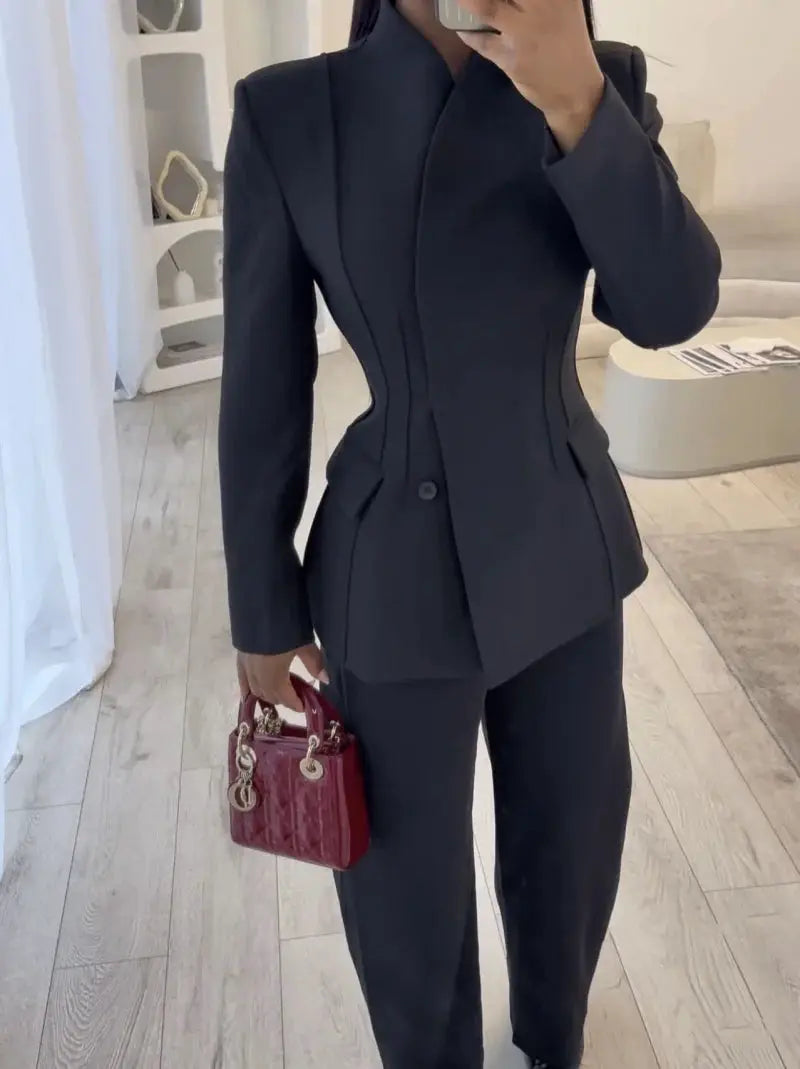 ETJ 2025 women's slim black suit jacket with high collar and matching trousers, woman holding a burgundy handbag