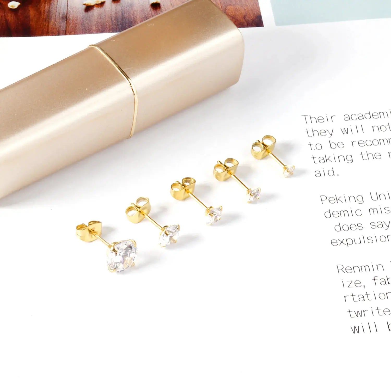 Five gold-tone stainless steel crystal stud earrings with clear cubic zirconia; 4-prong setting and butterfly backs