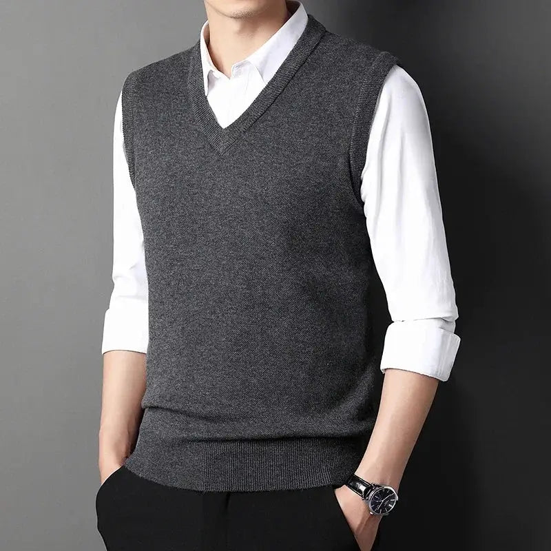 Men's charcoal gray V-neck knitted vest over a white shirt; casual, warm versatile top.