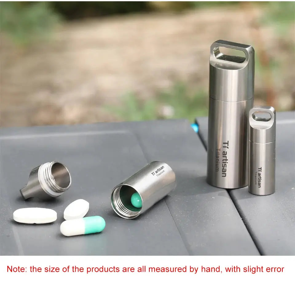 Three Tiartisan titanium mini EDC pill containers, portable sealed pill boxes; one open with a green pill, others closed.
