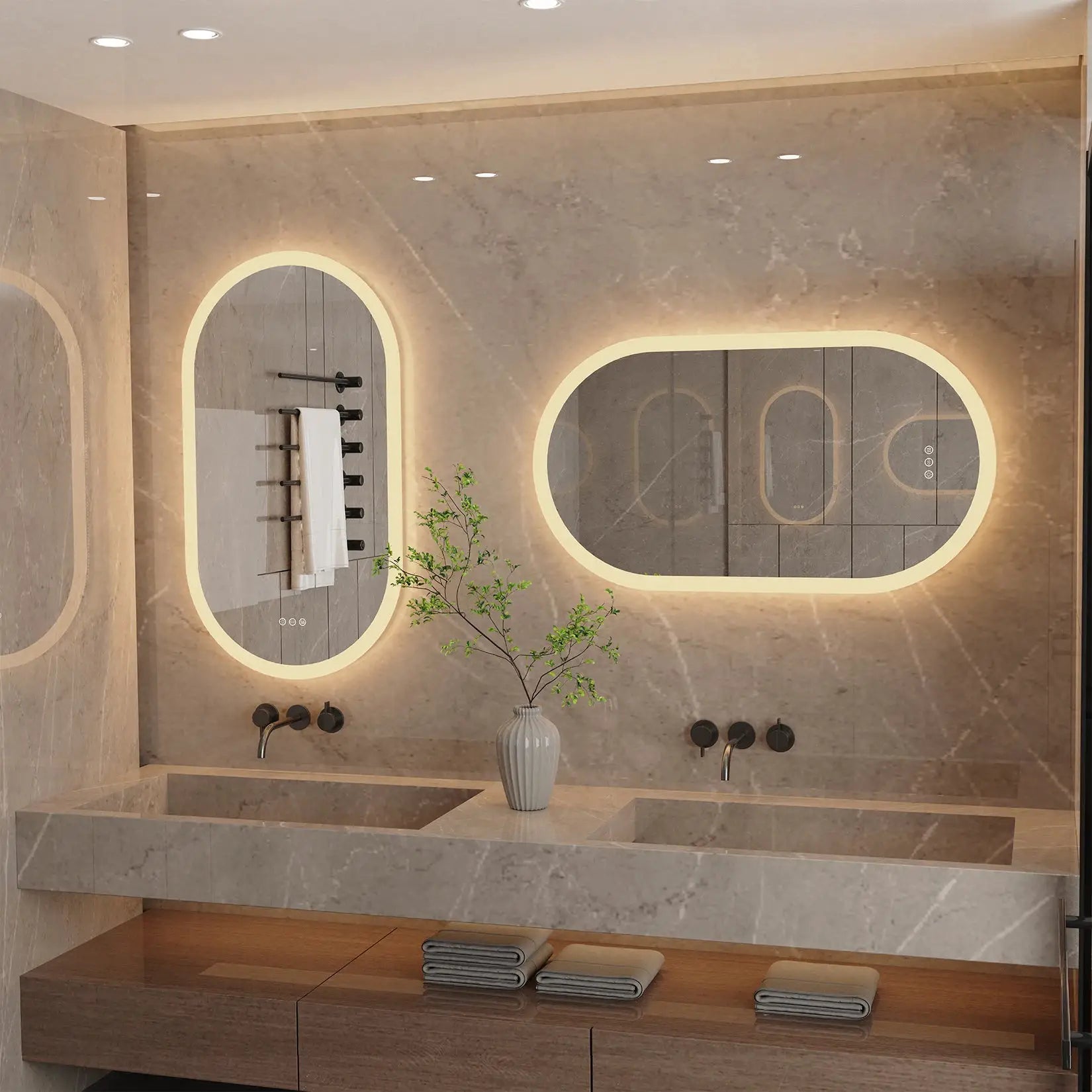 Pair of LED backlit oval frameless bathroom vanity mirrors with warm-white lights on marble wall