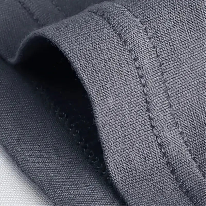 Men's boxer underwear in dark gray fabric; close-up view highlights soft knit material and reinforced stitching